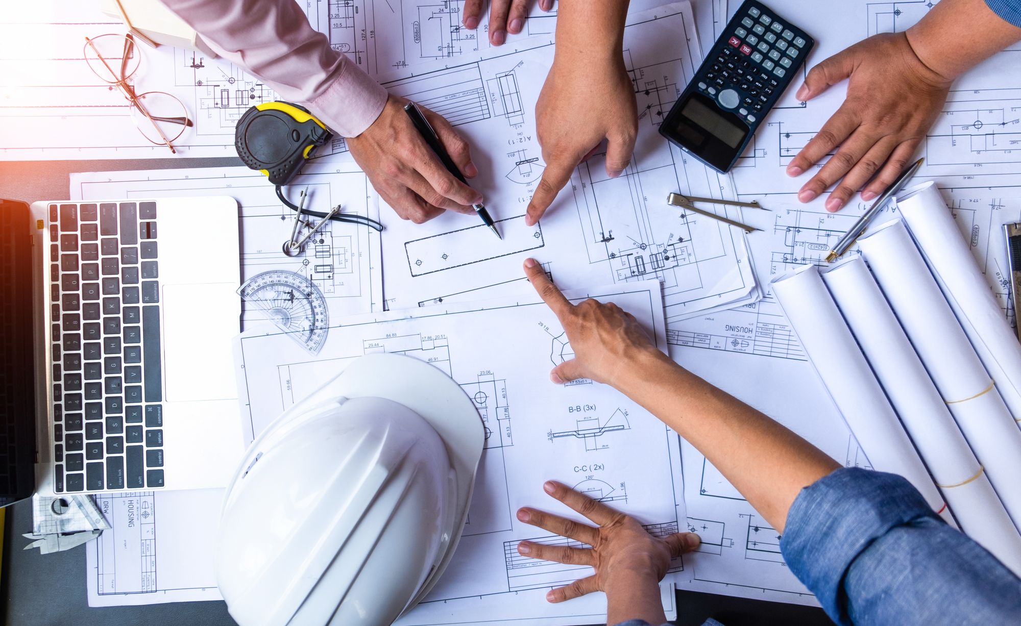 engineers pointing to building on blueprint